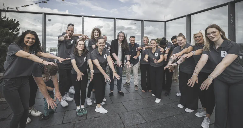 Das rehaMED-Team dehnt sich gemeinsam mit einem Augenzwinkern auf einer Dachterrasse über Dortmund